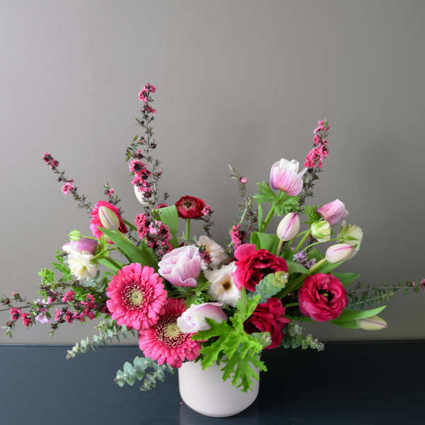 Pink and white mixed flower arrangement in a white vase