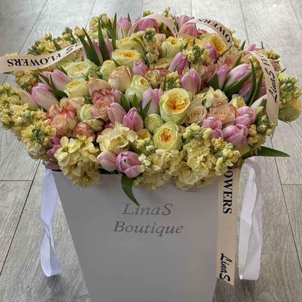 Large pastel bouquet in a white box with pink tulips and pale roses
