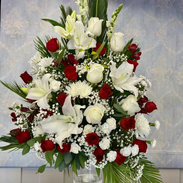 Tall red and white floral arrangement in a clear glass vase