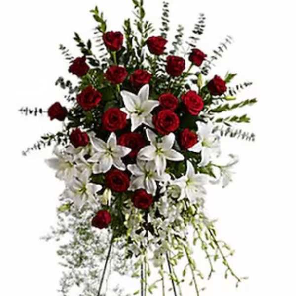 Standing floral spray of red roses and white lilies on an easel