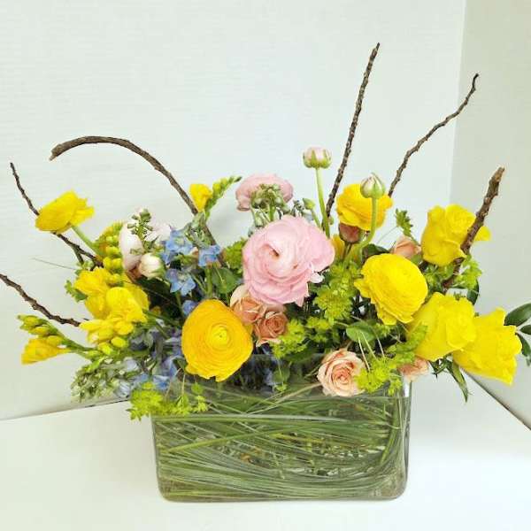 Yellow and pink mixed flower arrangement in a glass vase