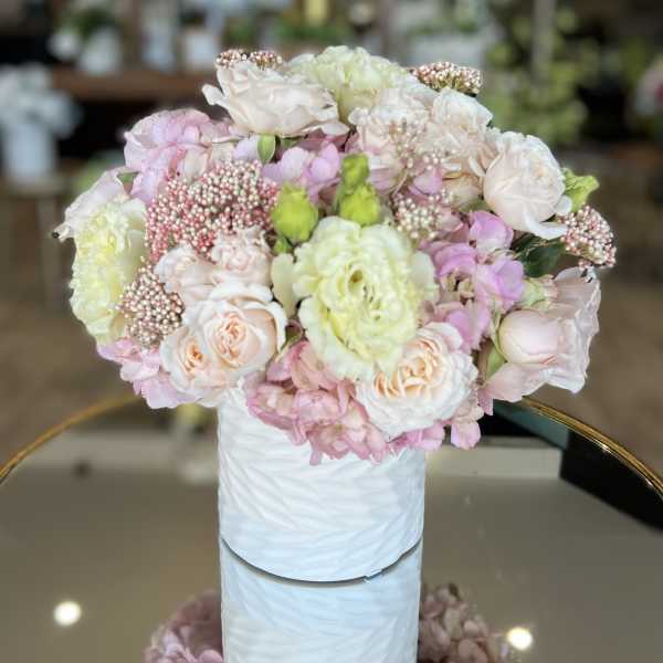Pastel bouquet of roses and hydrangeas in a white vase