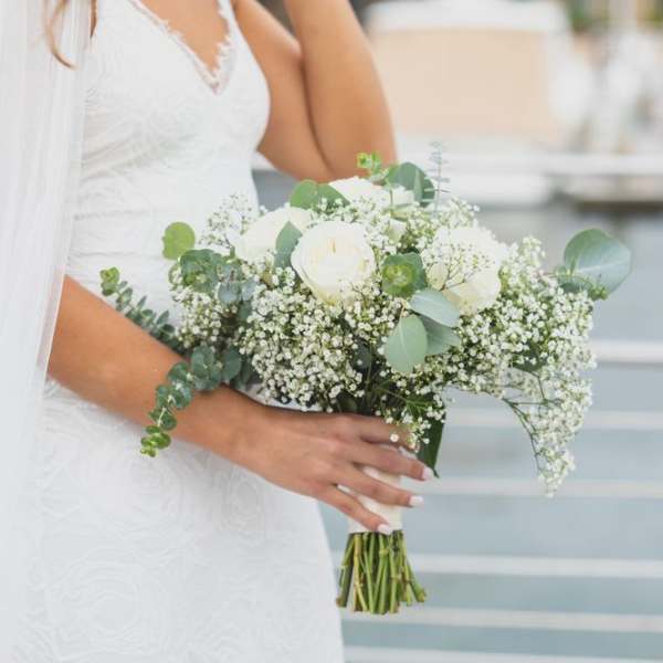 Bride holding a white rose bouquet with baby's breath and eucalyptus