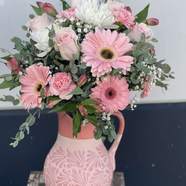Pink and white bouquet in a decorative ceramic pitcher