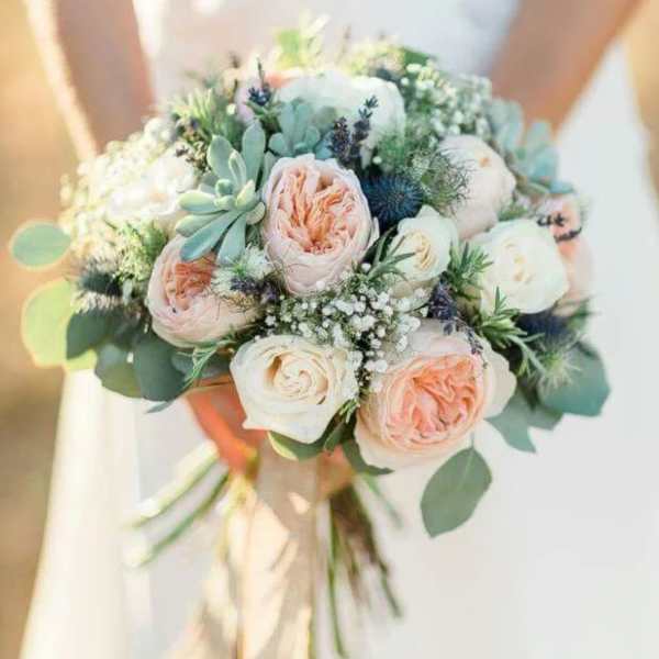 Bridal bouquet of blush and white roses with blue thistle and greenery
