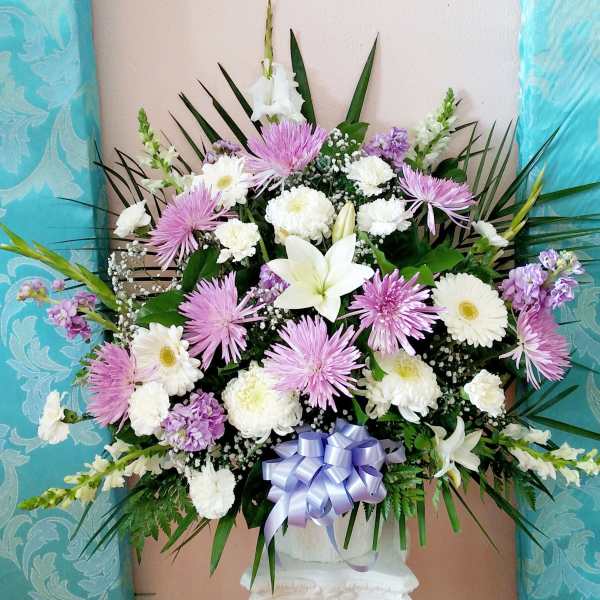 Large bouquet of white and lavender flowers with a ribbon bow