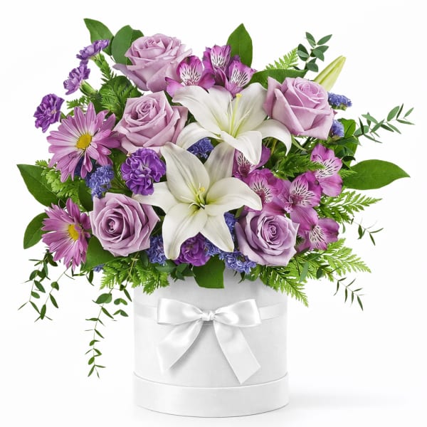 Lavender roses and white lilies in a white hatbox with a ribbon