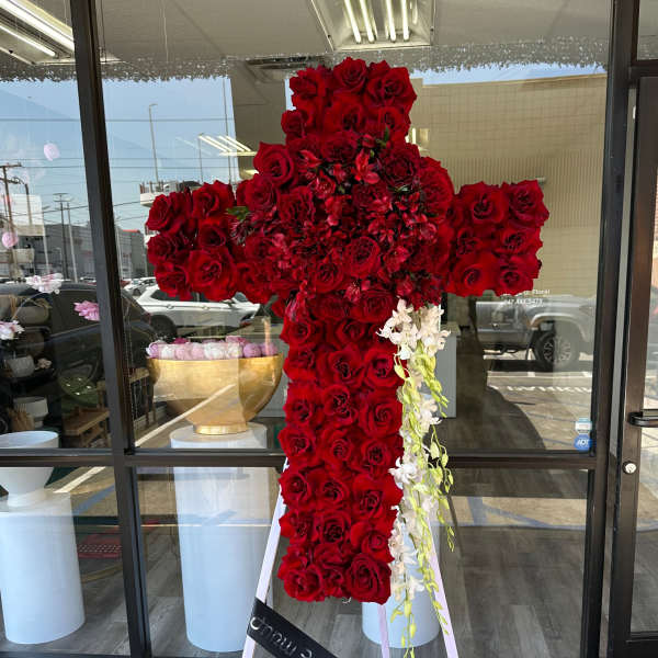 Large cross-shaped arrangement of red roses with white orchid accents