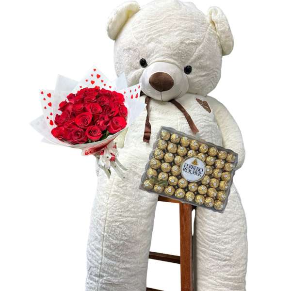 White teddy bear holding red roses and a box of chocolates