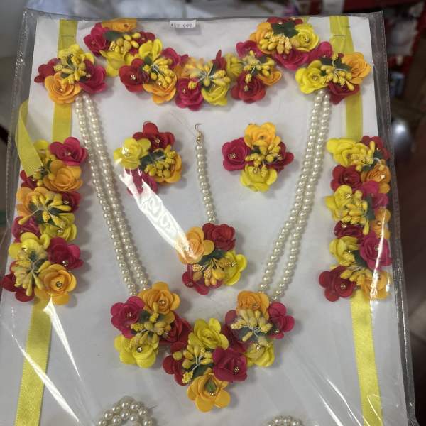 Decorative floral garland set with pink, yellow, and orange blossoms and pearl strands