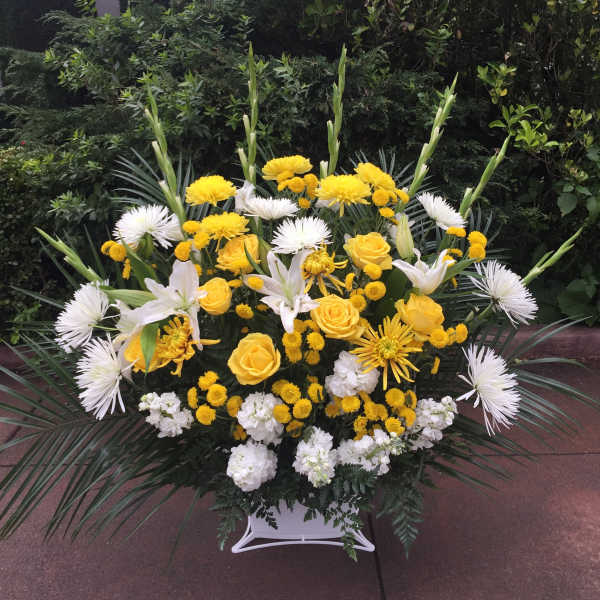 Yellow and white floral spray in a white container