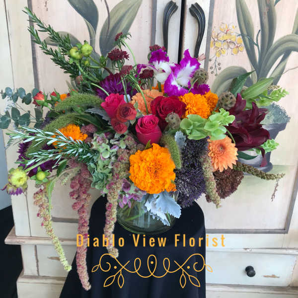Colorful mixed bouquet in a glass vase with roses and marigolds