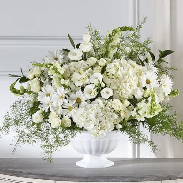 White floral arrangement in a white pedestal vase