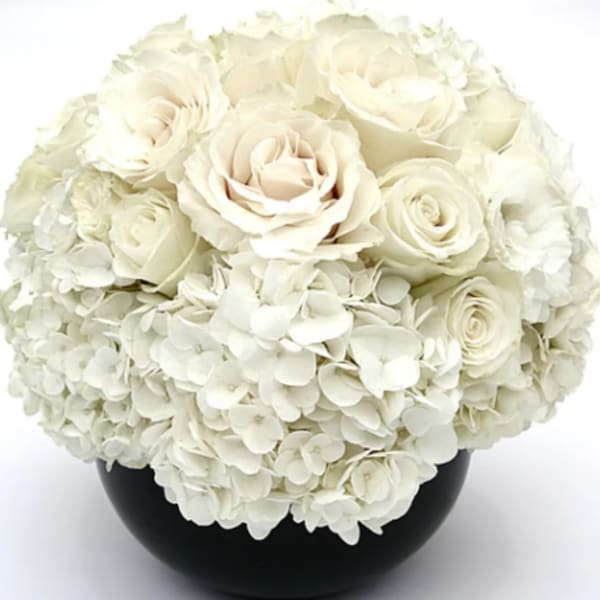 White roses and hydrangeas in a black vase