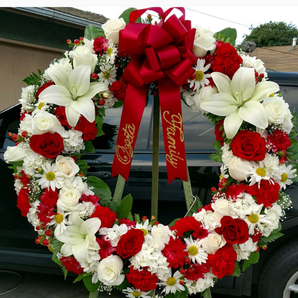 Large red, white, and cream floral wreath with a red bow