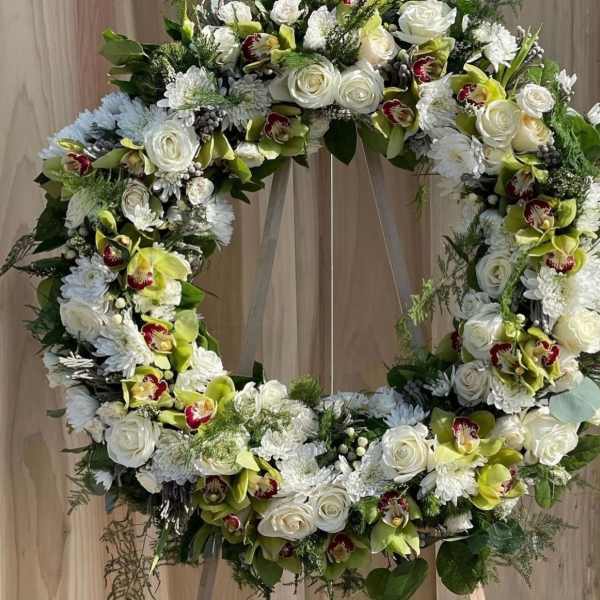 Large floral wreath with white roses, chrysanthemums, and green orchids