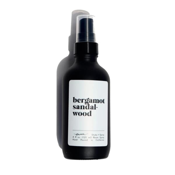 Matte black spray bottle with a white label reading bergamot sandalwood.
