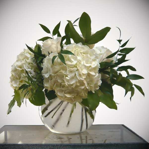 White hydrangea and rose arrangement in a clear glass vase
