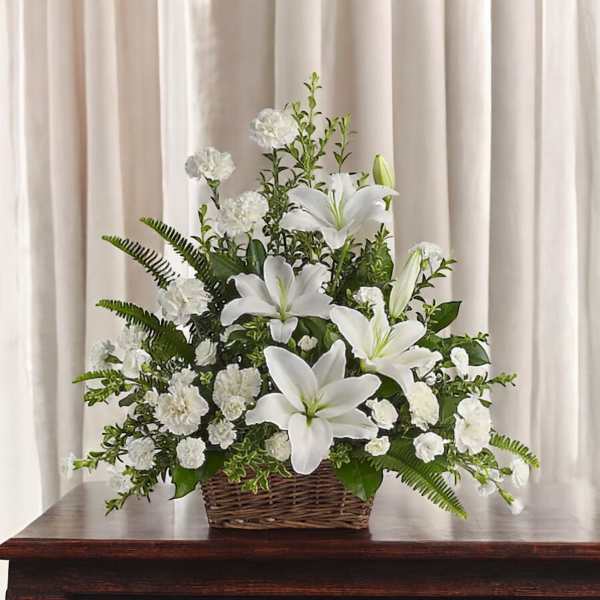 White lilies and carnations in a wicker basket