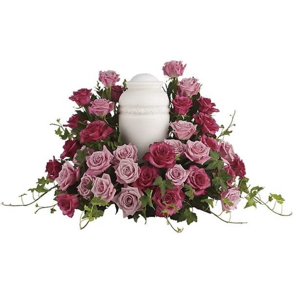 Pink and magenta roses arranged around a white urn