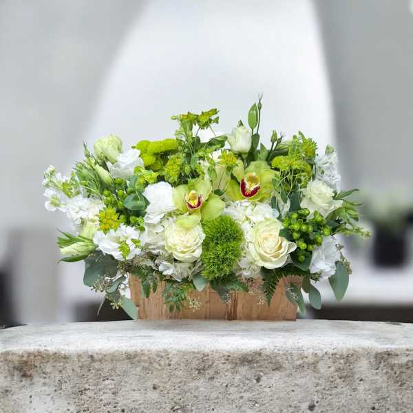 White and green floral arrangement in a wooden box