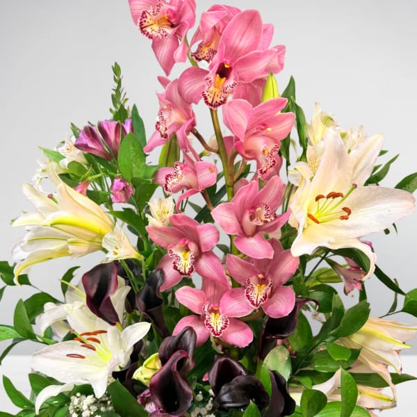 Bouquet of pink orchids, white lilies, and dark calla lilies