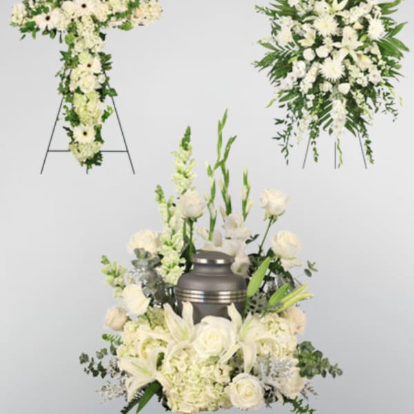 White funeral floral tributes with a cross, wreath, and urn arrangement