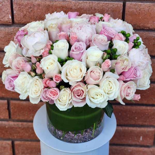 Pink and white rose bouquet in a glass vase