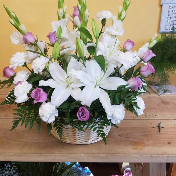 White lilies and pink roses in a wicker basket
