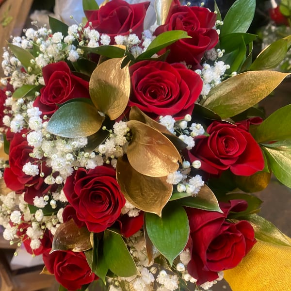 Bouquet of red roses with white baby's breath and gold leaves