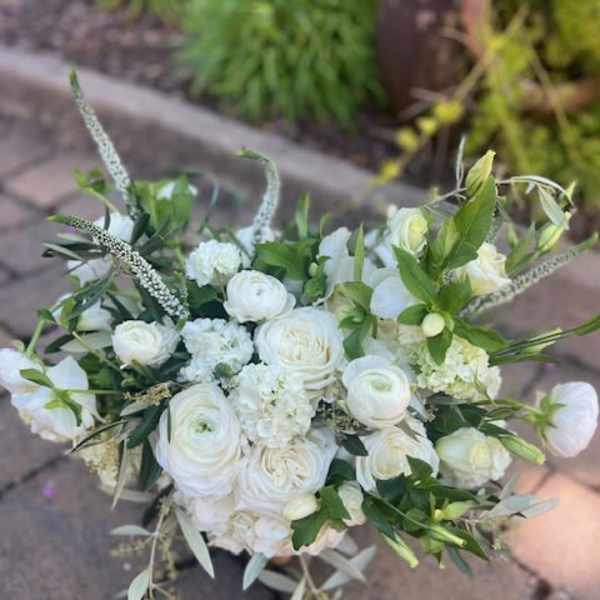White bouquet of roses and ranunculus with greenery