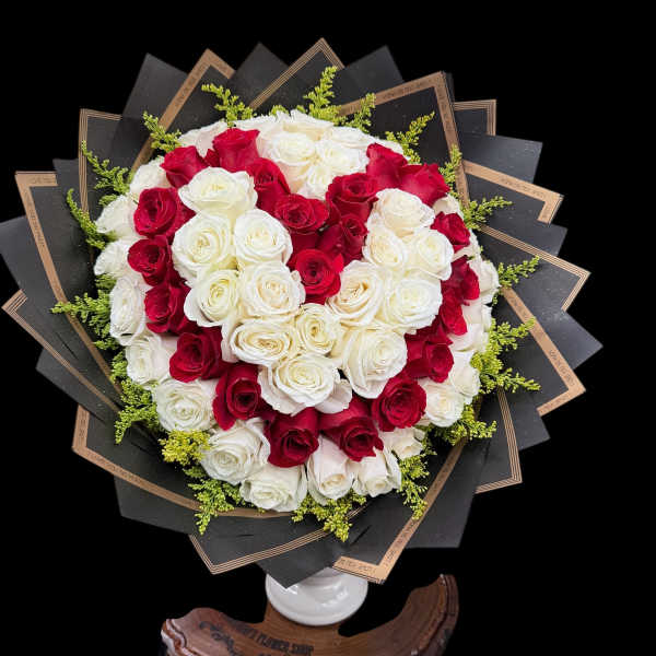 Heart-shaped bouquet of red and white roses in black wrap