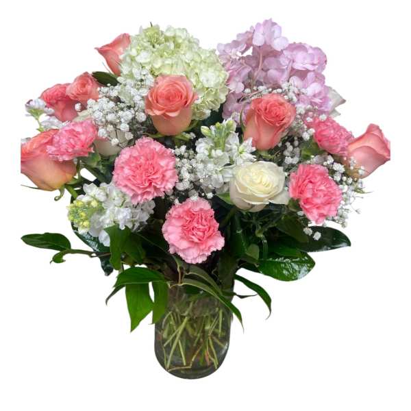 Pink roses and carnations in a glass vase with white and lavender blooms