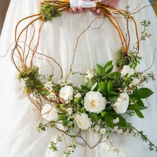 White floral wreath with greenery on a copper wire frame