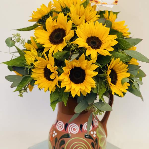 Sunflower bouquet in a painted ceramic pitcher
