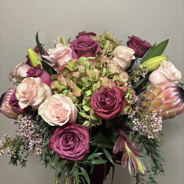 Bouquet of pink and magenta roses with hydrangea and protea