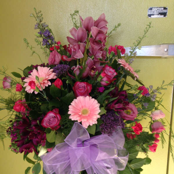 Large bouquet of pink and purple flowers with a lavender ribbon