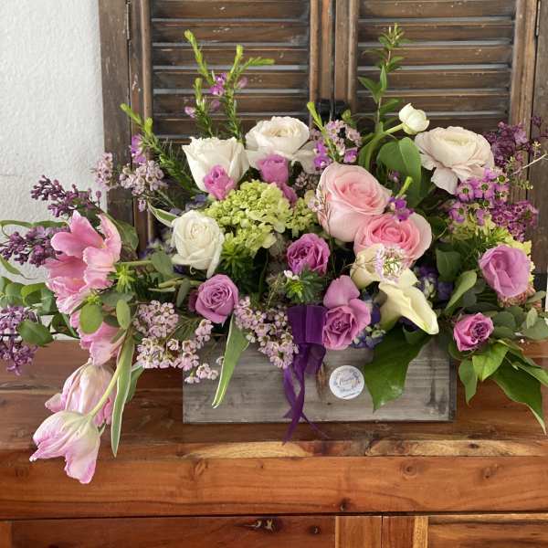 Mixed pink and white flower arrangement in a rustic wooden box