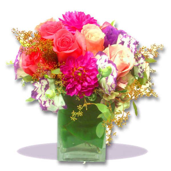 Colorful bouquet of roses and dahlias in a green glass vase