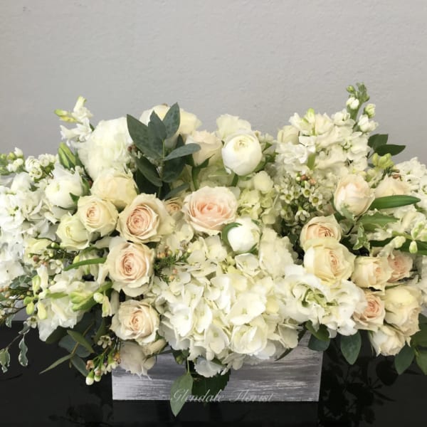 Cream and white floral arrangement in a gray wooden box