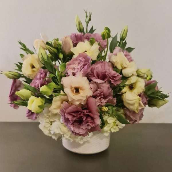 Bouquet of pink and cream lisianthus in a white vase