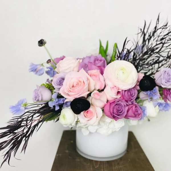 Bouquet of pink and purple roses in a white vase
