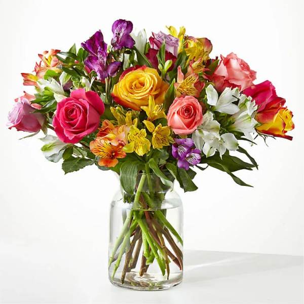 Mixed bouquet of roses and alstroemeria in a clear glass vase