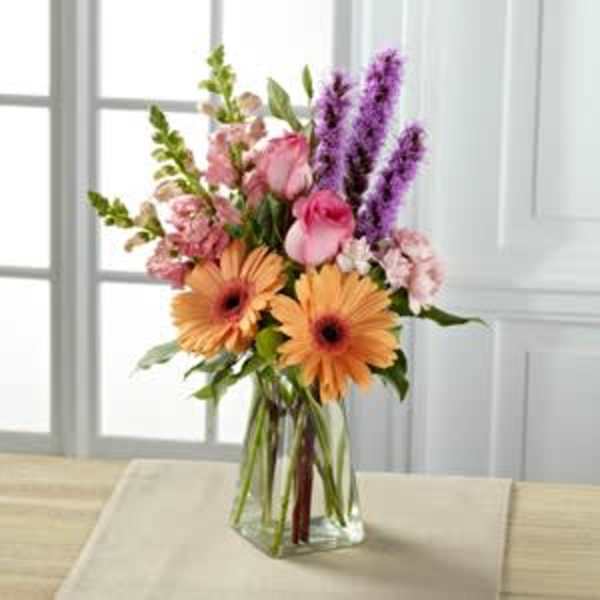 Bouquet of pink and orange flowers in a clear glass vase