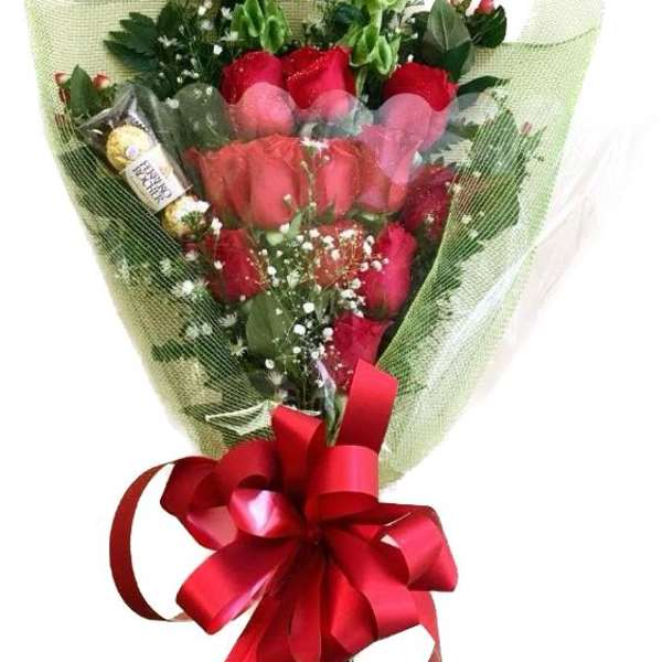 Bouquet of red roses wrapped in green mesh with a red ribbon