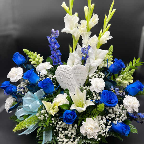 Blue and white floral sympathy arrangement with a memorial heart ornament