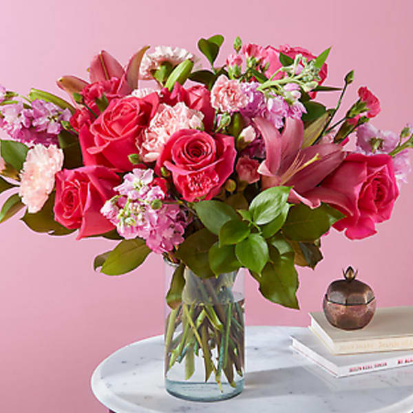 Pink rose bouquet in a clear glass vase on a table