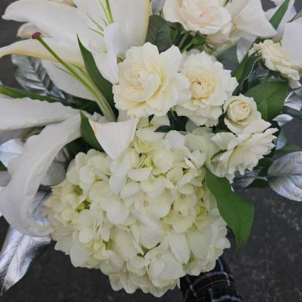 White floral bouquet with lilies, roses, and hydrangea