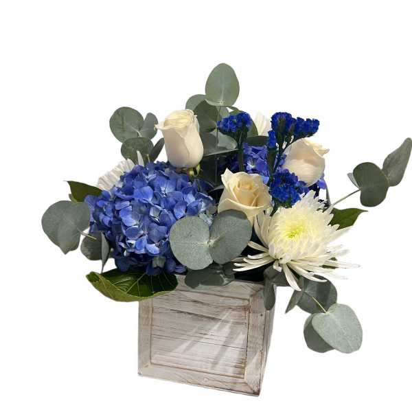 Blue hydrangeas and white roses in a rustic wooden box