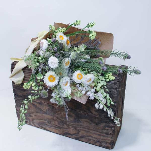 Rustic floral arrangement in a wooden box with white blooms and greenery